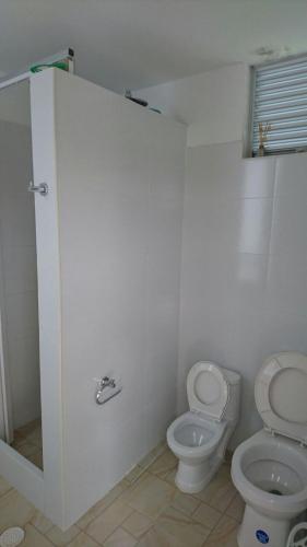 a white bathroom with a toilet and a sink at Casa Quinta Santana in Melgar
