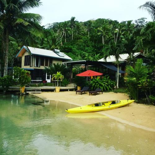 a yellow kayak on the beach next to a house at Salt Lake Lodge in Savusavu