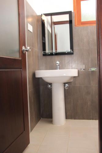 a bathroom with a sink and a mirror at Kalpa Place Hiriketiya in Hiriketiya