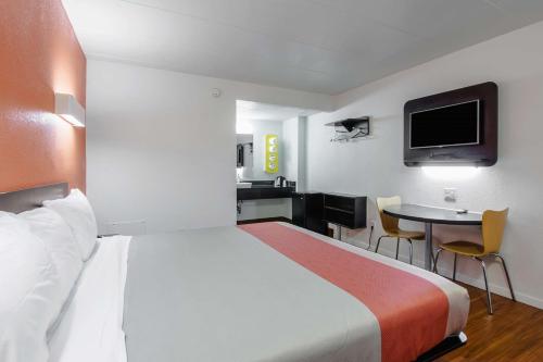 a hotel room with a large bed and a table at Motel 6-Glassboro, NJ - Rowan University in Glassboro