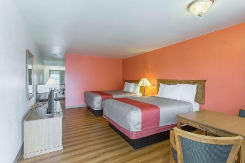 Una habitación de hotel con dos camas y paredes naranjas. en Motel 6-Lordsburg, NM, en Lordsburg