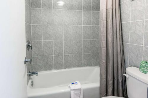 a bathroom with a white tub and a toilet at Motel 6-Glassboro, NJ - Rowan University in Glassboro