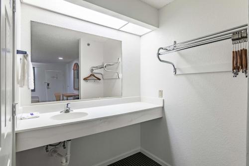 Baño blanco con lavabo y espejo en Motel 6-Azle, TX, en Azle