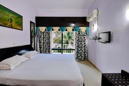 una camera con un grande letto e una finestra di Indo Hokke Hotel a Rajgir