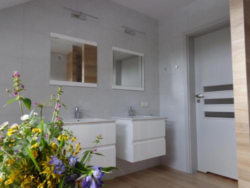 a white bathroom with two sinks and a mirror at Kwiatowe Zacisze in Szczyrk