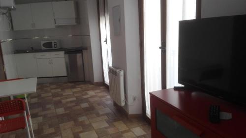 a living room with a television and a kitchen at VuT Dalia in Avila