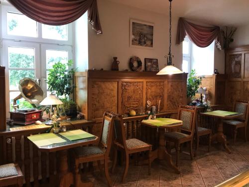 a dining room with tables and chairs and windows at Hotel am Schloss - Frankfurt an der Oder in Frankfurt/Oder