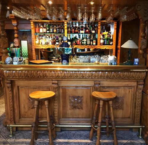 a bar with two wooden stools in front of it at Hotel am Schloss - Frankfurt an der Oder in Frankfurt/Oder