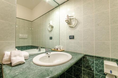 a bathroom with a sink and a bath tub at Hotel Federico II in LʼAquila