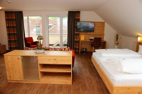 a bedroom with a bed and a desk in it at Landgasthof Adler Pelzmühle in Biederbach Baden-Württemberg