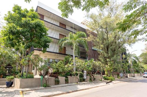 un edificio al lado de una calle con árboles en Somadevi Residence en Siem Riep