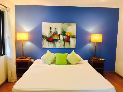 a bedroom with a white bed with two lamps at Villa Voilier in Mahe