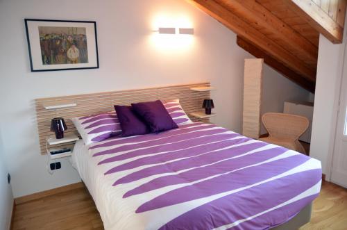 a bedroom with a large bed with purple pillows at Il Vicolo in Como