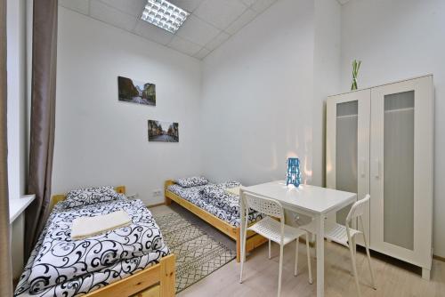 a room with two beds and a table and chairs at Laisves Avenue Hostel "Easy Kaunas" in Kaunas