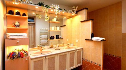 La salle de bains est pourvue de 2 lavabos et d'un grand miroir. dans l'établissement Villa Cartarana, à Bonifacio