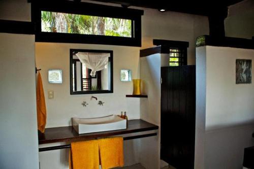 y baño con lavabo y espejo. en Playa Selva en Tulum