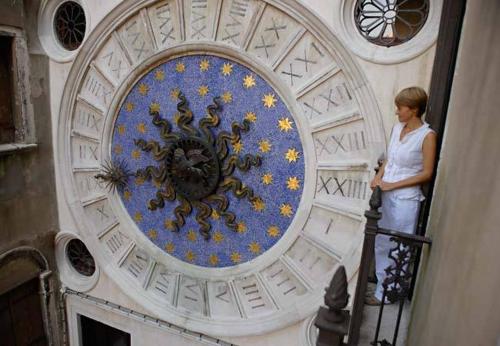 a woman standing on a staircase next to a clock at Best Windows in Venice