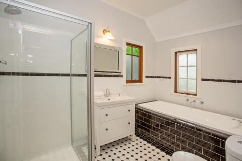 a bathroom with a tub and a sink and a shower at Oak Tree Lodge in Rhyll