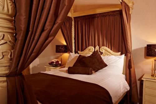 a bedroom with a canopy bed with white sheets and pillows at New Continental Hotel; Sure Hotel Collection by Best Western in Plymouth