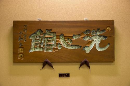 a sign on a wall with asian writing on it at Tachibana Shikitei in Kaga