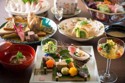 a table with plates of food and bowls of food at Tachibana Shikitei in Kaga