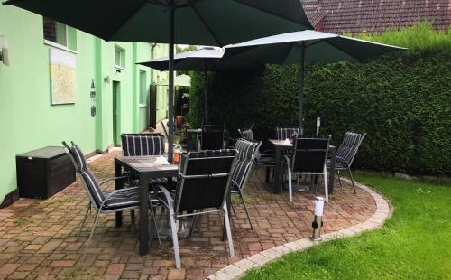 a patio with tables and chairs under an umbrella at Hotel am Schloss - Frankfurt an der Oder in Frankfurt/Oder