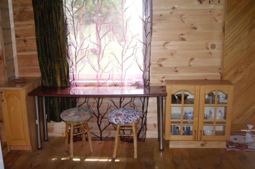 a table and two chairs in a room with a window at Traku Horizontai in Trakai