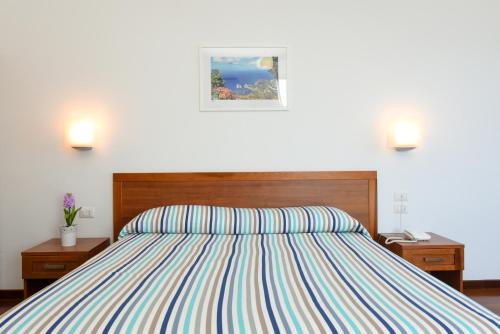 a bedroom with a bed with a striped comforter at Villa Crawford in Sant'Agnello