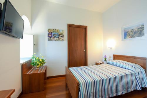 a small bedroom with a bed and a television at Villa Crawford in Sant'Agnello