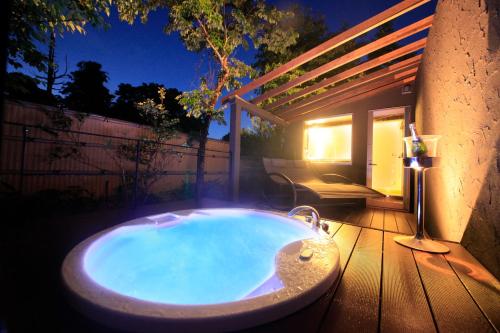 a jacuzzi tub sitting on a deck with a patio at Hakone Fuga - Adult Only in Hakone
