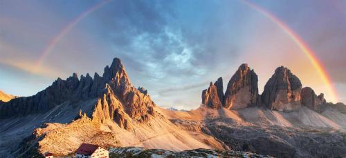 a rainbow over a mountain range with rocks at Ka' Tari in Ponte nellʼAlpi