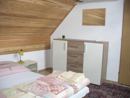 1 dormitorio con cama y techo de madera en Penzion Jarka, en Lednice