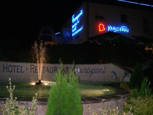 a hotel sign and a fountain in front of a building at Hôtel Restaurant de L'Europort in Saint-Avold