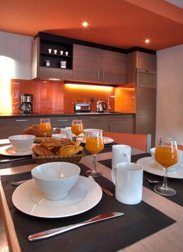 a kitchen with a table with food and wine glasses at Residence Montana Plein Sud in Val Thorens