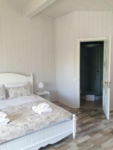a bedroom with a white bed with towels on it at Relax villa Poduzska in Sinyak