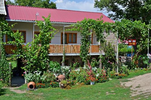 a house with a garden in front of it at Guest House Aleksandre in T'mogvi