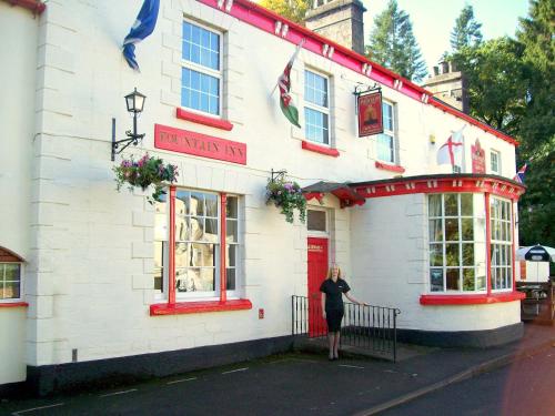 a woman standing in front of a building at The Fountain Inn in Parkend