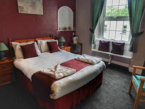 a bedroom with a large bed and a window at The Fountain Inn in Parkend