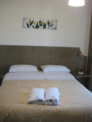 a bedroom with a bed with two towels on it at Il corbezzolo in Linguaglossa