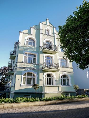 a blue and white building with a tree in front of it at Apartamenty Villa Artis in Świnoujście