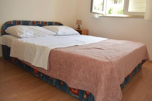 ein Bett in einem Schlafzimmer mit einer Decke drauf in der Unterkunft Apartment Rina in Vantačići