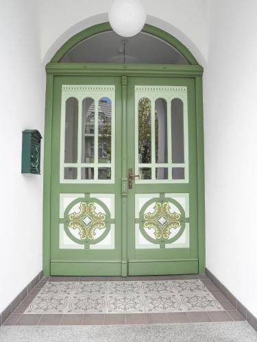 a green door in a room with a window at Apartamenty Villa Artis in Świnoujście