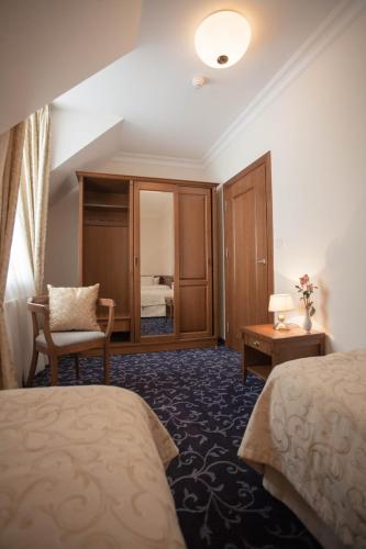 a hotel room with two beds and a chair at Apartamenty Villa Artis in Świnoujście