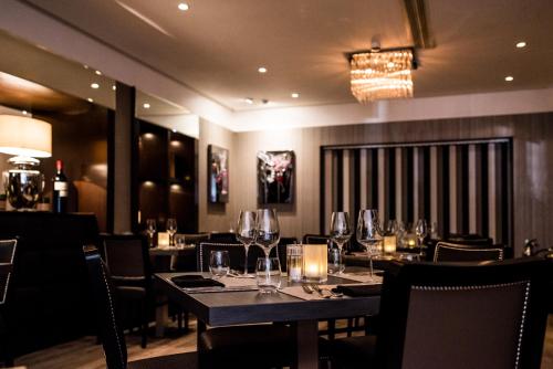 a dining room with tables and chairs and a chandelier at The Winchester Hotel and Spa in Winchester