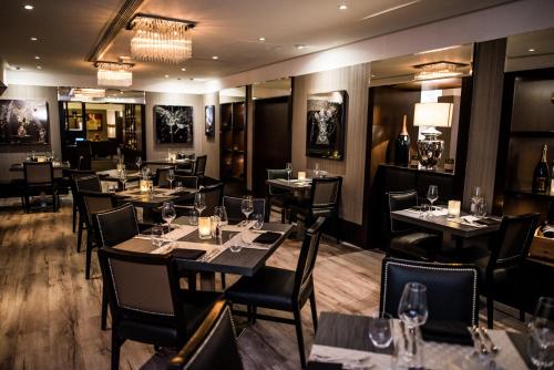 a restaurant with tables and chairs with wine glasses at The Winchester Hotel and Spa in Winchester