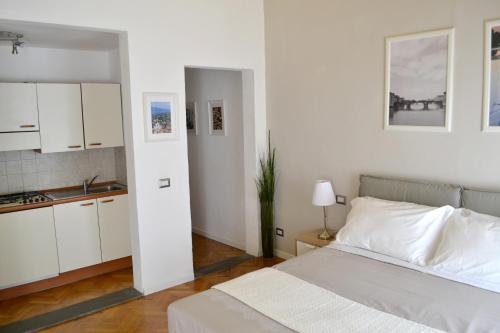 a white bedroom with a bed and a kitchen at Domus Duomo in Florence