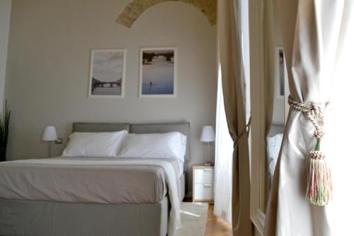 a bedroom with a white bed and a window at Domus Duomo in Florence