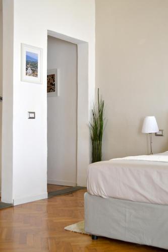 a white bedroom with a bed and a plant at Domus Duomo in Florence