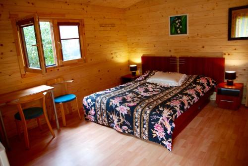 a bedroom with a bed in a wooden cabin at Audrones sodyba in Šventoji