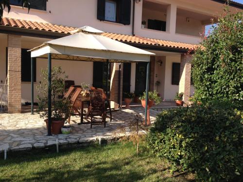 een patio met een tafel en een parasol bij Cherry House Bed&Breakfast in Campobasso